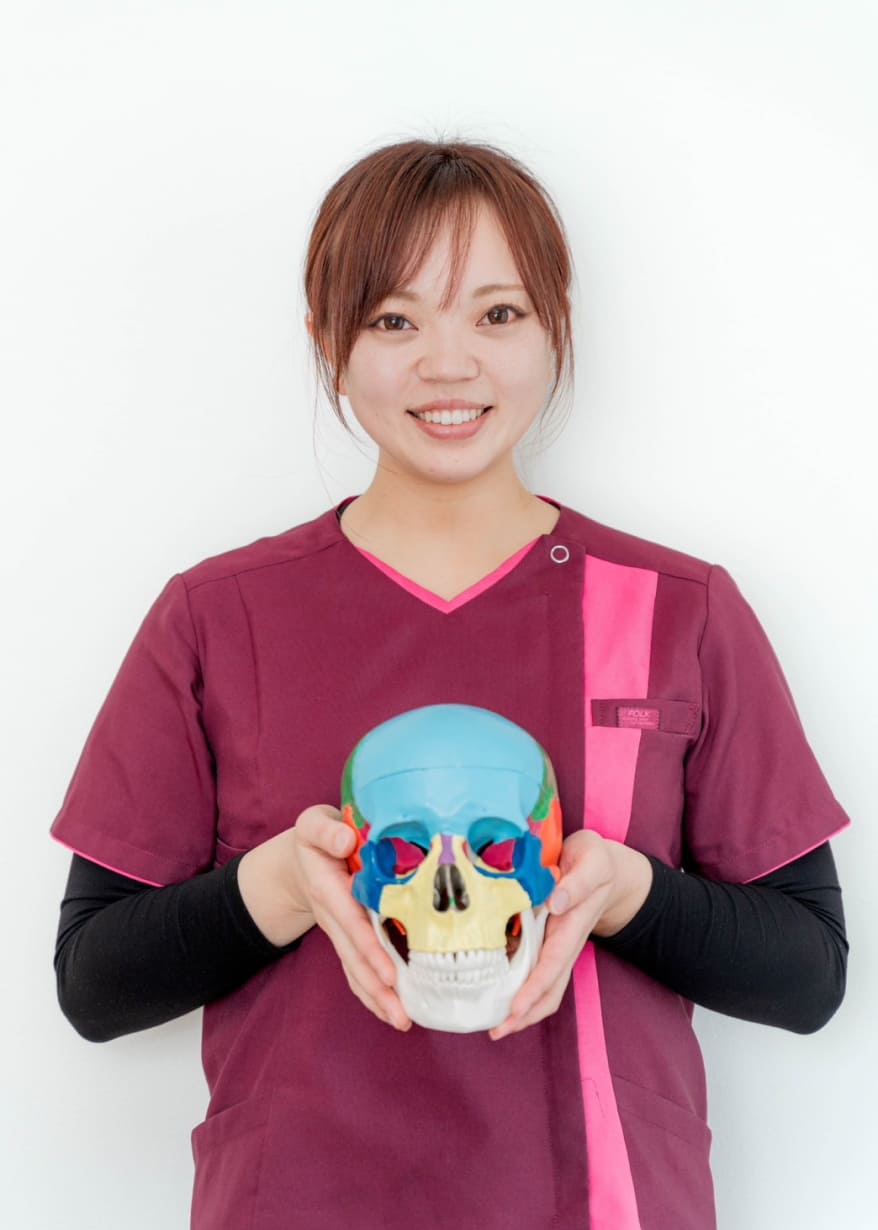 明るい部屋で整体師が正面を向いて笑顔